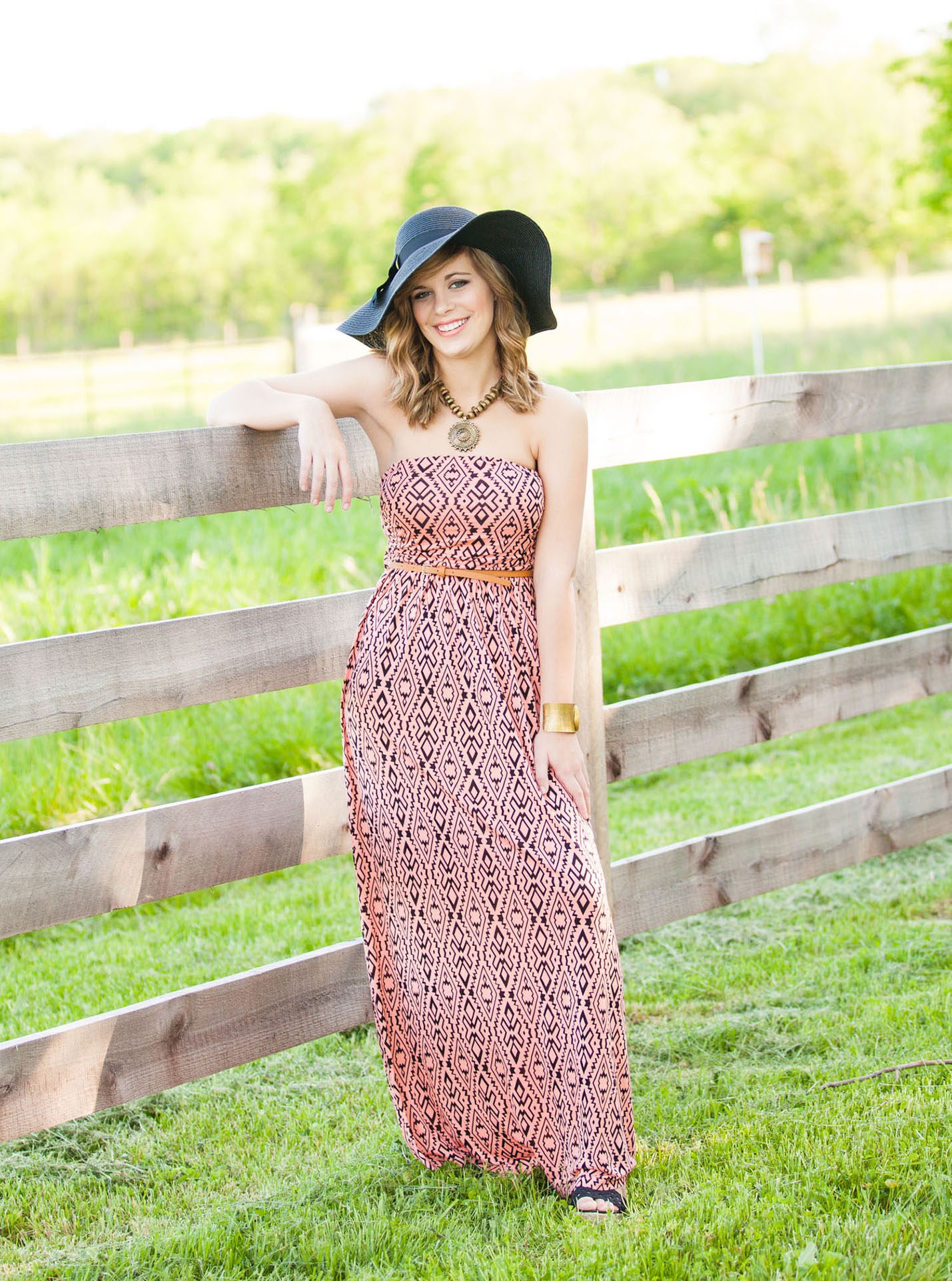 senior photography session in a field wearing a dress and hat in Columbus, OH