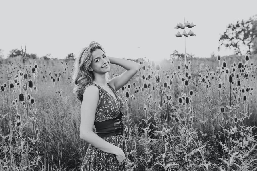 black and white image of senior girl with cattails