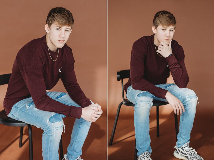 Grove City Senior Pictures of Alex sitting on a black chair with rust colored backdrop
