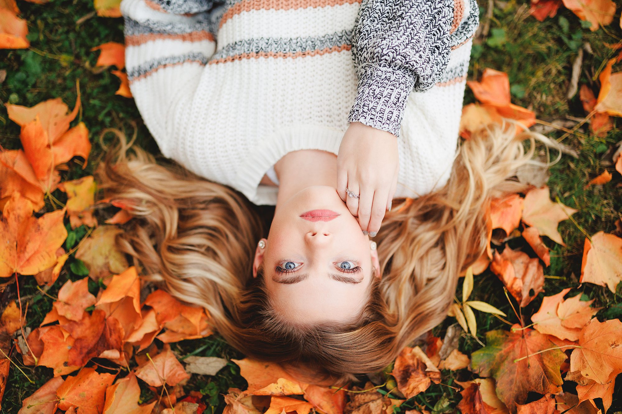 Overhead view of Central Crossing High School Senior Darby laying in fall leaves at Scioto Grove Metro Park