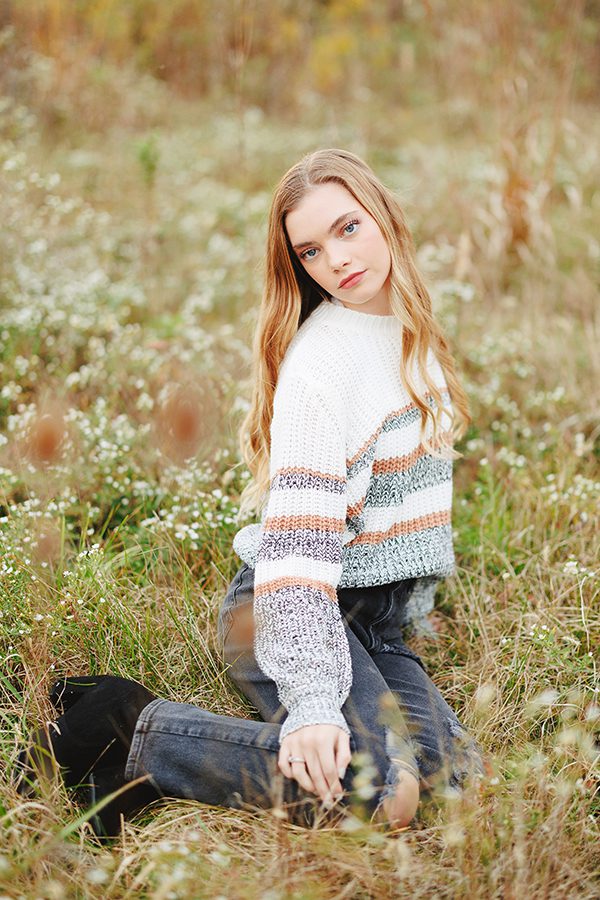 Central Crossing High School Senior Darby laying in field of flowers at Scioto Grove Metro Park in Grove City, Ohio